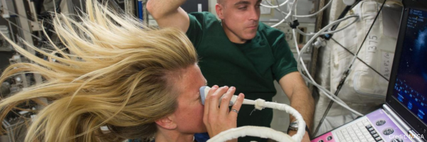 Astronaut performing a diagnostic ultrasound scan aboard the International Space Station as part of space health research.